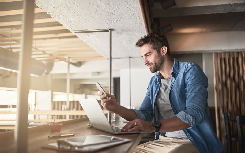 man using laptop and cellphone